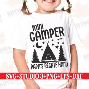 May include: A white t-shirt with a black graphic design that says "mini camper" with a tent, stars, and a crescent moon. The text below the graphic says "Papa's rechte Hand".