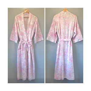 May include: A pink and white floral print dressing gown with long sleeves and a tie belt.