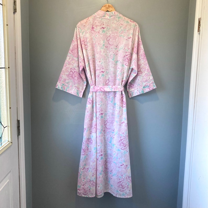 May include: A pink and blue floral print dressing gown with a tie belt.