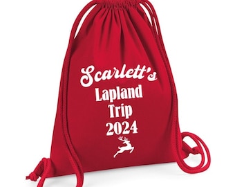 May include: Red drawstring bag with white text that says "Scarlett's Lapland Trip 2024" and a white reindeer silhouette.