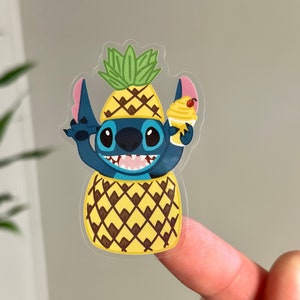 May include: A blue cartoon character wearing a pineapple costume and holding a yellow pineapple ice cream cone. The character has large eyes and a wide smile. The pineapple costume has a green top and a yellow body with brown markings.