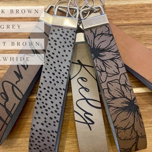 May include: Five different leather keychains with various designs and colors. The keychains are labeled "Dark Brown", "Grey", "Light Brown", "Rawhide", and "Kelly".