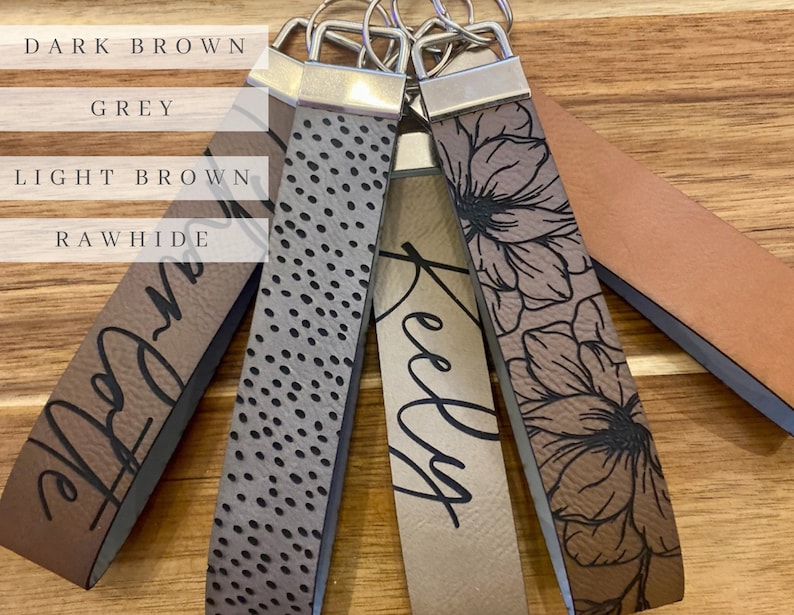 May include: Five different leather keychains with various designs and colors. The keychains are labeled "Dark Brown", "Grey", "Light Brown", "Rawhide", and "Kelly".