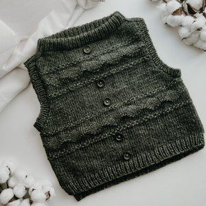 May include: A dark green knitted waistcoat with a cable knit pattern and button fastenings.