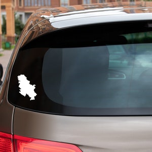 Könnte beinhalten: Ein silbernes Auto mit einer weißen Umrandung des Landes Serbien auf der Heckscheibe.