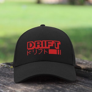 May include: A black baseball cap with a red pixelated logo that says "DRIFT" and "ドリフト" in Japanese.