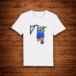 Könnte beinhalten: Weißes T-Shirt mit einem grünen Frosch, der ein blaues Hemd und Shorts trägt, an einer Klimmzugstange hängt und ein Gewicht hebt.