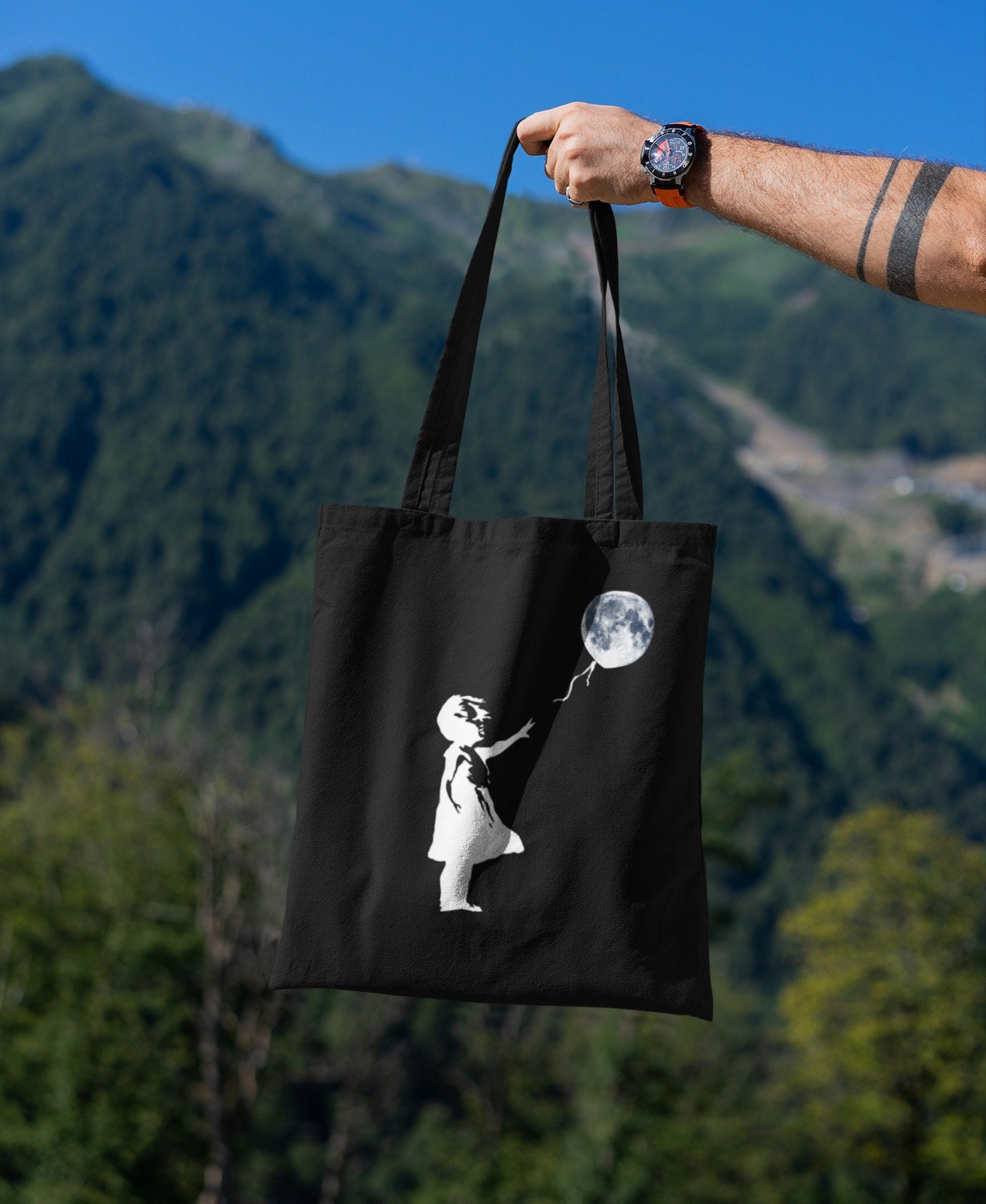 バンクシー風の風船と月を持つ少女のストリートアート / オーガニック