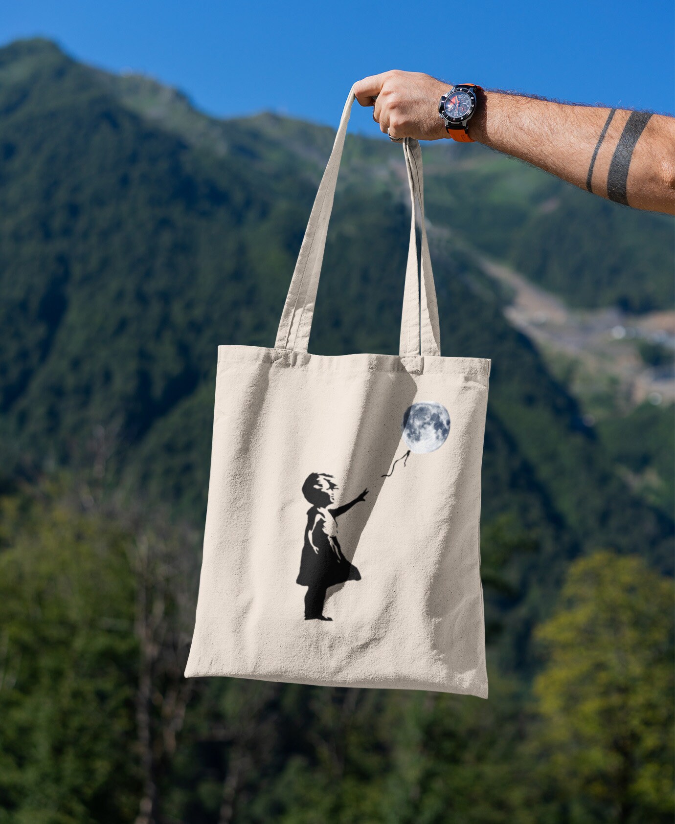 バンクシー風の風船と月を持つ少女のストリートアート / オーガニック