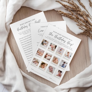 Op de afbeelding: Drie witte papieren spelkaarten met zwarte tekst. Eén kaart leest "Who Knows the Birthday Best!" en heeft invulvragen. Een andere kaart zegt "First Birthday Ever" en heeft invulvragen. De derde kaart zegt "How Many Months Was the Birthday Boy?" en heeft babyfoto's.