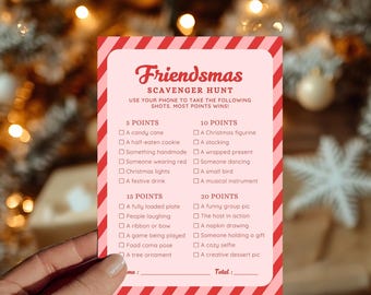 May include: A pink and red Friendsmas Scavenger Hunt game card with a list of photo challenges. The card includes point values and prompts like "Christmas lights" and "a cozy selfie".