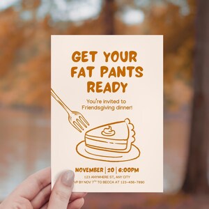 Op de afbeelding: Een crèmekleurige uitnodigingskaart met bruine tekst en illustraties. De tekst luidt "GET YOUR FAT PANTS READY" en "You're invited to Friendsgiving dinner!" Een stuk taart en een vork zijn ook afgebeeld.