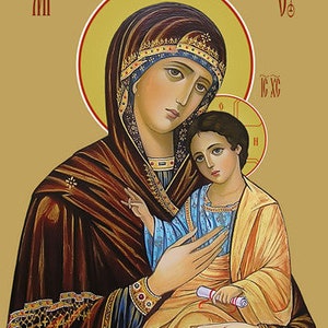 May include: An icon depicting a woman and child with halos. The woman wears a dark brown robe with gold accents and a decorated head covering. The child is in a gold and blue garment, holding a scroll. The background is a light gold color.