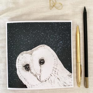 May include: A black and white illustration of a barn owl with large, round eyes, set against a dark background with white stars. The owl is looking directly at the viewer.