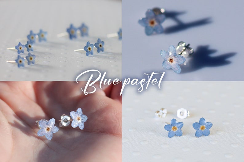 May include: A pair of delicate earrings featuring small blue forget-me-not flowers with silver posts. The flowers have a light blue and white pastel color with a yellow center.