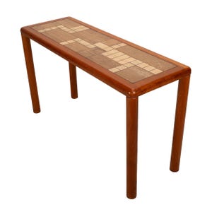 May include: A rectangular wooden console table with a mosaic tile top. The table has four rounded legs and a dark brown finish. The top features a geometric pattern in shades of brown and beige. The table is approximately 48 inches long.