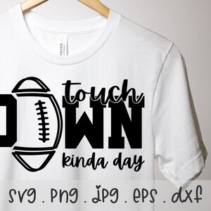 Puede incluir: Una camiseta blanca con un dise&ntilde;o gr&aacute;fico negro que dice "Touchdown kinda day" con un gr&aacute;fico de f&uacute;tbol. El gr&aacute;fico est&aacute; en blanco y negro.