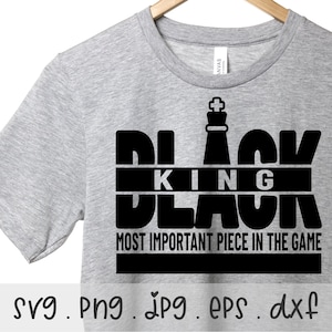 May include: A gray t-shirt with a black graphic design that says "Black King Black" with a chess piece on top. The text below the graphic says "Most Important Piece In The Game".