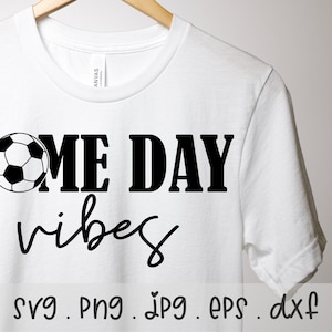 May include: White t-shirt with black text that reads "Game Day Vibes" and a black and white soccer ball graphic. The text "svg. png. jpg. eps. dxf" is printed below the graphic.