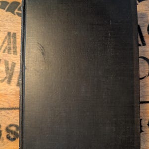 May include: A white ceramic mug with a black handle and the text "But First, Coffee" in a black, handwritten-style font. The mug is on a white surface.