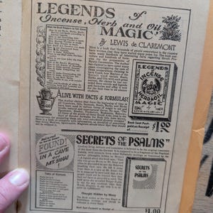 May include: A vintage book page featuring advertisements for two books: Legends of Incense, Herb and Oil Magic by Lewis de Claremont and Secrets of the Psalms. The page contains black text on a cream background with illustrations of book covers.