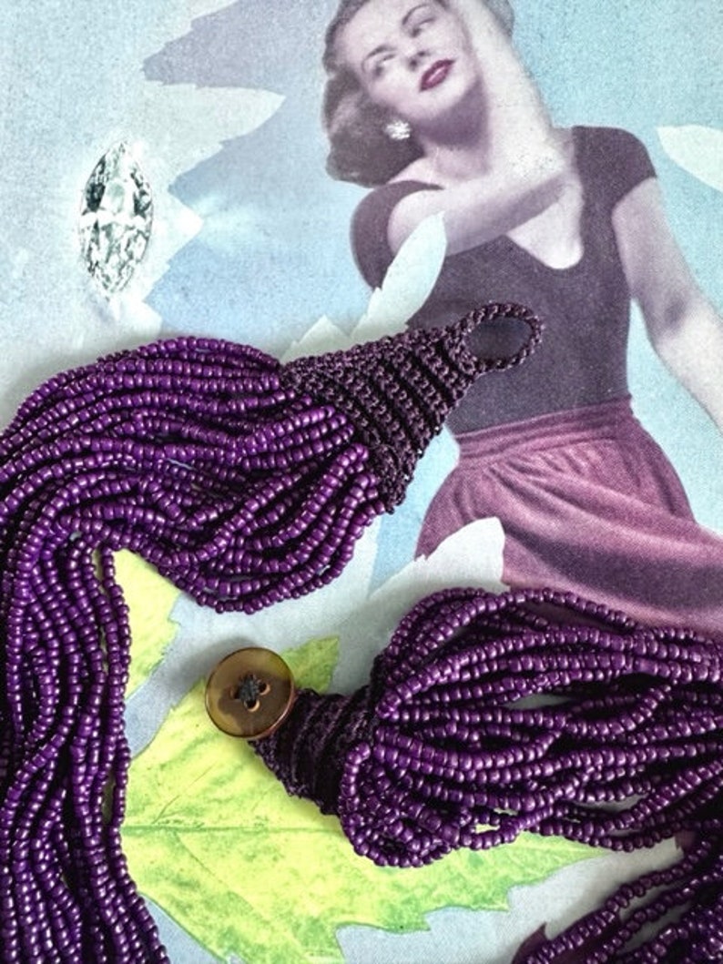 May include: A long purple beaded necklace with a button clasp. The necklace is made of many strands of small beads and is very long.