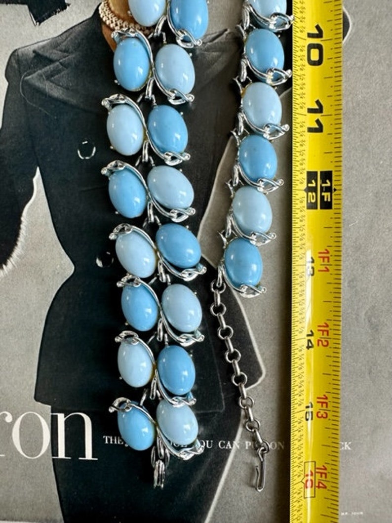 K&ouml;nnte beinhalten: Eine vintage Halskette aus blauen und wei&szlig;en Glasperlen mit einer silbernen Kette. Die Halskette ist etwa 38 cm lang.