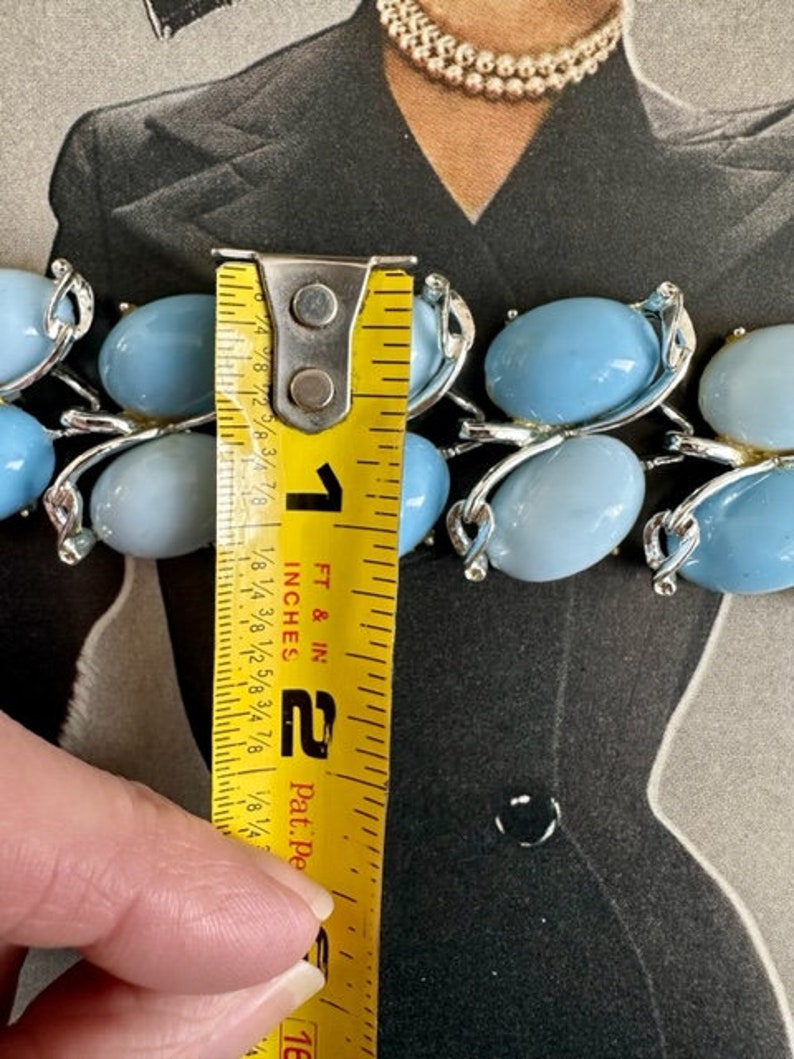 K&ouml;nnte beinhalten: Eine blaue und silberne Statement-Halskette mit ovalen Steinen. Die Halskette wird mit einem Ma&szlig;band gemessen und ist 5 cm lang.