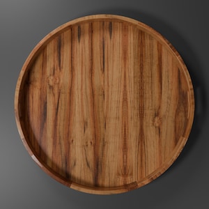 Puede incluir: Una bandeja redonda de madera con borde elevado. La bandeja es de madera marrón claro con vetas marrones más oscuras. Diseñada para servir o exhibir.