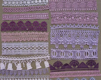 May include: A collection of various purple and lavender lace trim strips arranged in two columns, featuring diverse floral, geometric, and scalloped patterns. A 12-inch ruler is positioned at the bottom, showing the scale of the lace pieces.