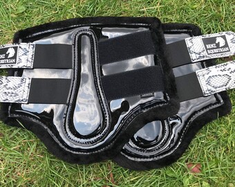 May include: Pair of black and white horse leg boots with a snake print design and the text "Benz Equestrian" on the straps.