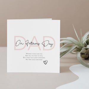 May include: A white Father's Day card with the word "DAD" in a soft pink hue. The text "On Father's Day" is written in elegant script. Additional text includes a heartfelt message and a small heart illustration.