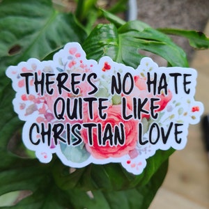 Puede incluir: Una pegatina blanca con flores rosas y el texto "There's no hate quite like Christian love."