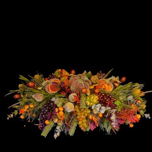 Puede incluir: Un centro de mesa oto&ntilde;al decorativo con calabazas, uvas y follaje en tonos naranja, marr&oacute;n y verde. El arreglo incluye calabazas artificiales, uvas y otros elementos de temporada, perfecto para la decoraci&oacute;n de oto&ntilde;o.