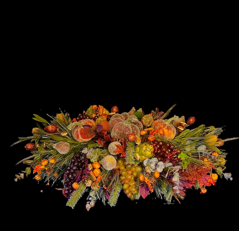 Puede incluir: Un centro de mesa oto&ntilde;al decorativo con calabazas, uvas y follaje en tonos naranja, marr&oacute;n y verde. El arreglo incluye calabazas artificiales, uvas y otros elementos de temporada, perfecto para la decoraci&oacute;n de oto&ntilde;o.