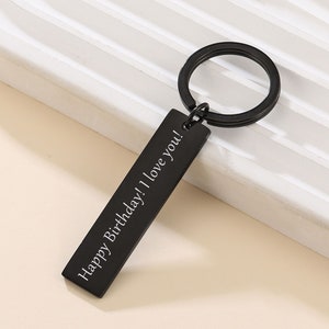 May include: Black metal keychain with a rectangular tag that reads "Happy Birthday! I love you!"
