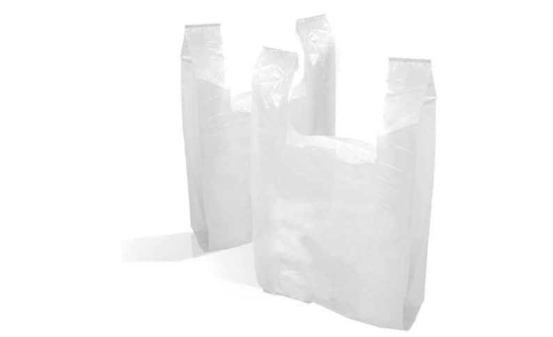 Op de afbeelding: Drie witte plastic boodschappentassen, gevouwen en gestapeld op een witte achtergrond.