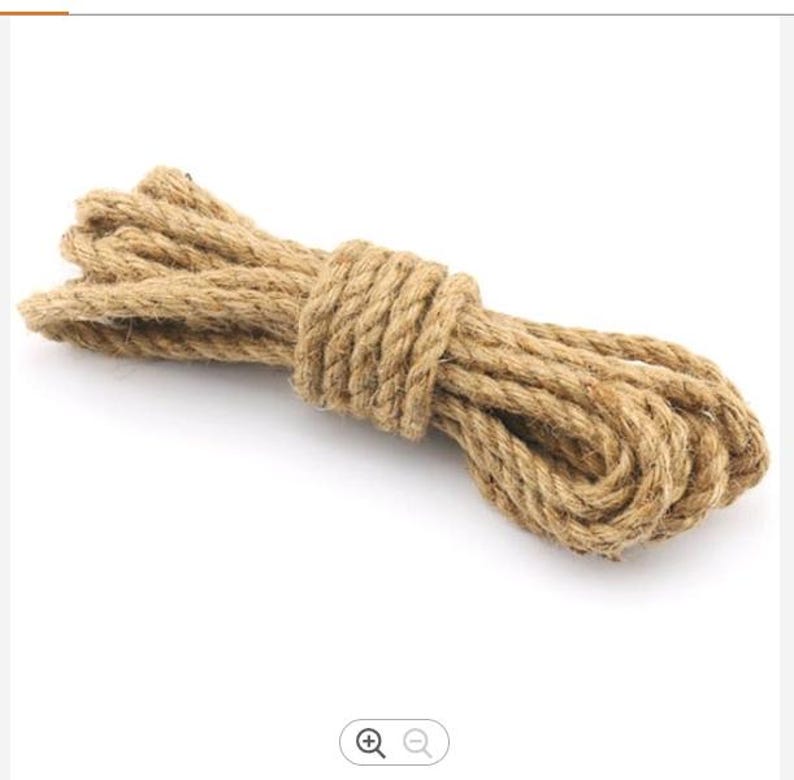 May include: A close-up of a thick, natural brown jute rope coiled on a white background.
