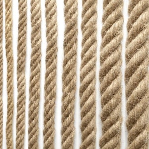 May include: A close-up of various natural fiber ropes in different thicknesses. The ropes are made of a natural material, such as jute or hemp, and have a rough, textured surface. The ropes are arranged in a vertical pattern, with each rope running from the top to the bottom of the image.
