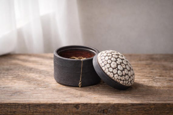 A genuinely wheel-thrown ceramic box with a lid — the kind of tactile, one-of-a-kind object that feels like a tiny sculpture on a dresser.