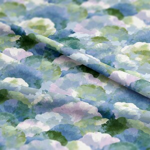 Könnte beinhalten: Nahaufnahme eines Stoffes mit einem Aquarellmuster. Das Design zeigt sich überlappende, fächerförmige Motive in Blau-, Grün- und Lavendeltönen. Der Stoff hat ein weiches, fließendes Aussehen mit sichtbaren Falten und Knitter.
