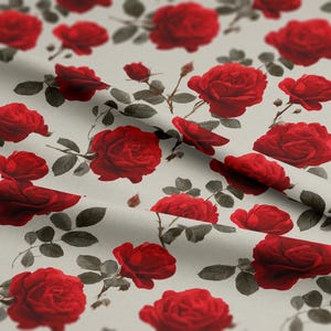 Puede incluir: Una tela con un patrón repetido de rosas rojas y hojas verde grisáceo sobre un fondo gris claro. Las rosas están en varias etapas de floración, creando un diseño floral clásico. La tela se utiliza probablemente para ropa o decoración del hogar.