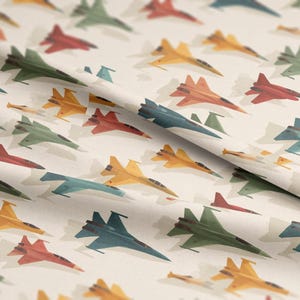 Puede incluir: Patrón repetido de aviones de combate coloridos en tonos de rojo, verde, amarillo y azul sobre un fondo crema. Los aviones están representados de forma estilizada e ilustrativa, creando un diseño lúdico y dinámico.