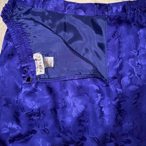 Peut inclure: Gros plan sur un pantalon bleu vif &agrave; motif floral. Le pantalon a une taille &eacute;lastique et une fermeture &eacute;clair. L'&eacute;tiquette indique "Adrianna Papell". Le tissu a un aspect soyeux.