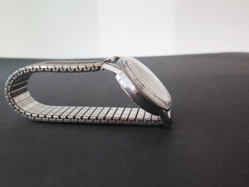 Op de afbeelding: Een zilveren polshorloge met een zilveren metalen band. De wijzerplaat van het horloge is rond en heeft een zilveren bezel.