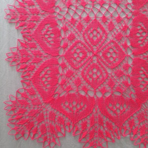 May include: A close-up of a pink crocheted lace doily with a delicate floral pattern.