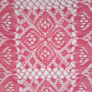 May include: A close-up of a pink crocheted lace doily with a delicate, intricate pattern.