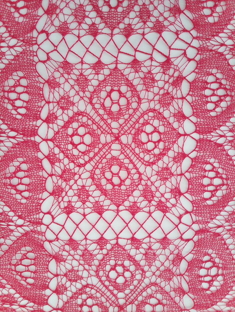 May include: A close-up of a pink crocheted lace doily with a delicate, intricate pattern.