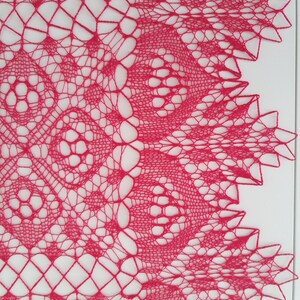 May include: A delicate pink crocheted lace doily with a circular design and intricate patterns.