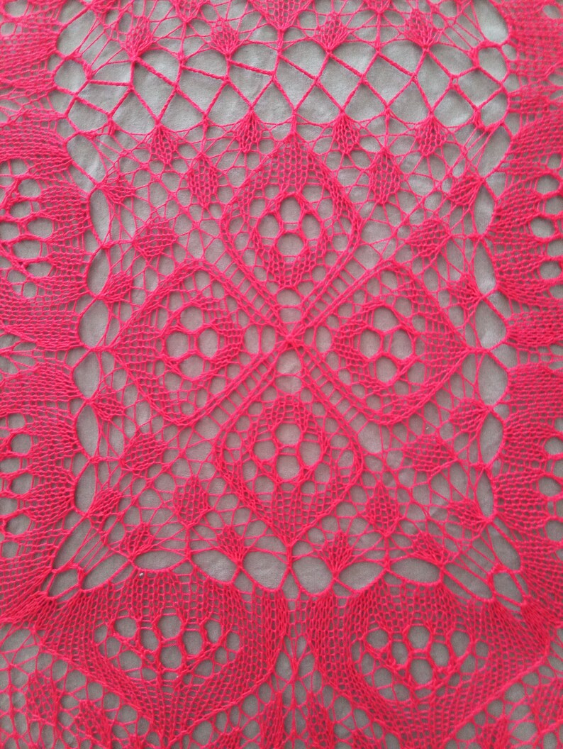 May include: A close-up of a pink crocheted lace doily with a delicate, intricate pattern.
